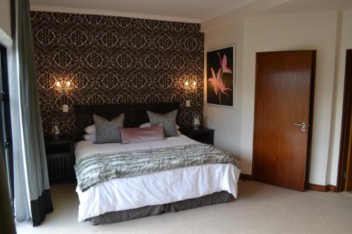 a bedroom with a large bed with a black wall at Pearl Valley-Golf Safari SA in Paarl