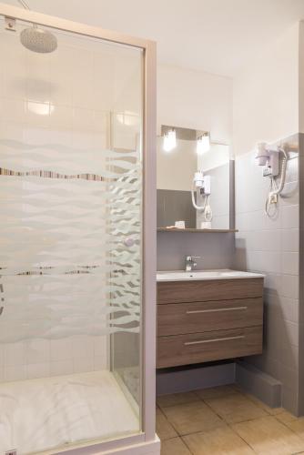 une salle de bain avec une douche en verre et un lavabo dans l'établissement Hôtel-Restaurant La Belle Poule - Contact Hotel, à Rochefort