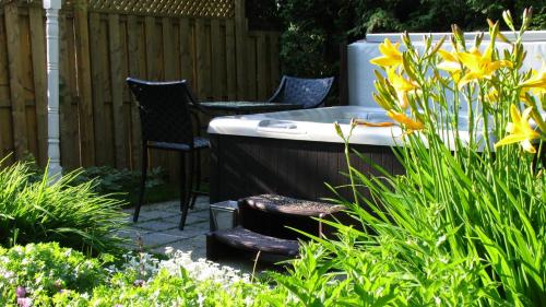 a garden with two chairs and a bath tub at La Belle Victorienne in Magog-Orford