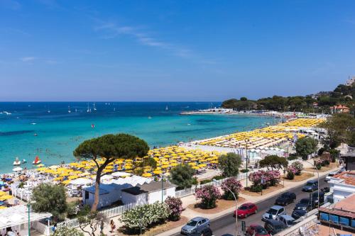 a beach with many yellow umbrellas and the ocean at Mondello Beach Rooms - by the sea in Mondello