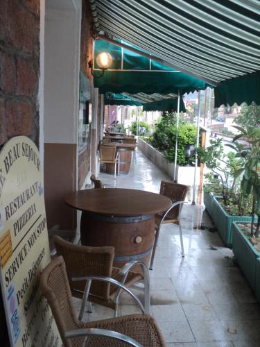 a table and chairs sitting outside of a restaurant at Hotel & Restaurant Le Beau Sejour in Porto Ota