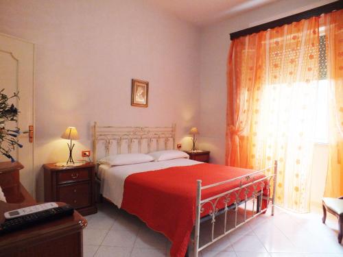 a bedroom with a bed with a red blanket at Zia Pia in Locogrande