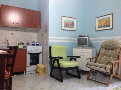 a kitchen with two chairs and a tv in a room at Stella Del Sud in Cuglieri