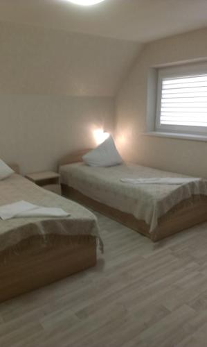 two beds in a room with a window at Prie Ąžuolo in Zarasai