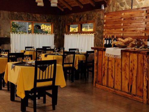 um restaurante com mesas e cadeiras com toalha de mesa amarela em Los Molles Complejo Turistico em Los Molles