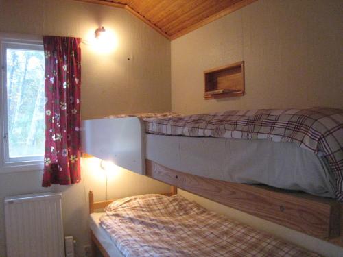 a bedroom with two bunk beds and a window at Snäckan in Klintehamn