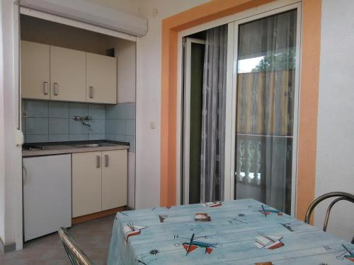 a kitchen with a table with a blue table cloth on it at Villa Jadranka Pakostane in Pakoštane
