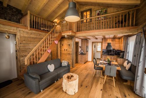 ein Wohnzimmer mit einem Sofa und einem Tisch in der Unterkunft Braito's Seaside Lodges und Suites in Haldensee