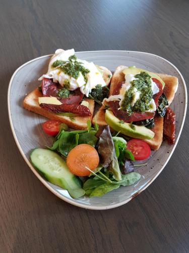 a plate of food with sandwiches and a salad at The Lion & Key Hotel in London
