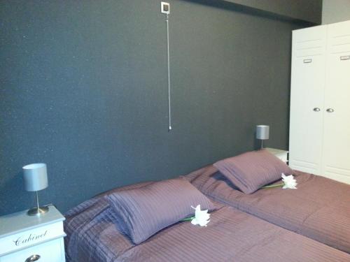 ミッデルケルケにあるBeach Palaceのベッドルーム1室(花の飾られたベッド1台付)