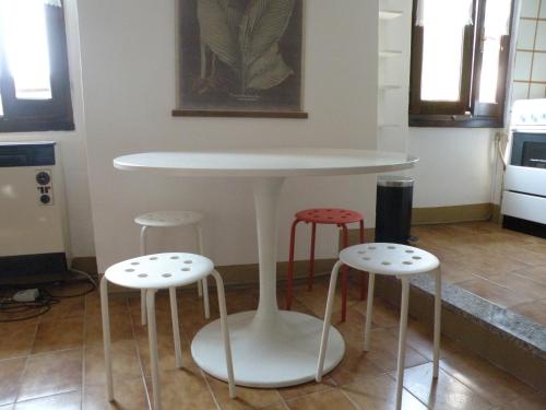 ヴァレンナにあるCasa Cuboの白いテーブルとスツール付きのキッチン用品