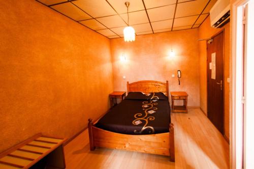 a bedroom with a wooden bed in a room at Hotel & Restaurant Le Beau Sejour in Porto Ota