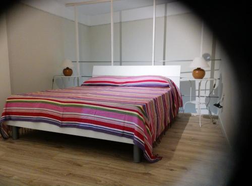 アヴェトラーナにあるcasa ad hocのベッドルーム1室(ストライプ毛布付きのベッド1台付)