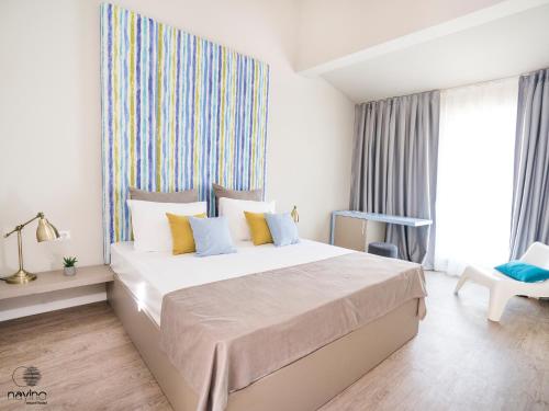 a bedroom with a large bed and a large window at Nayino Resort Hotel in Mamaia Nord