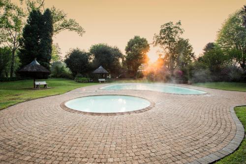 a hot tub in a brick circle in a garden at Merry Pebbles Resort in Sabie