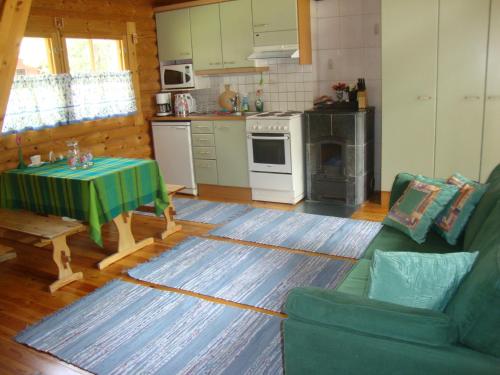 a living room with a table and a kitchen at Mökki Eteläranta in Mikkeli