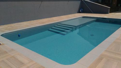 a swimming pool with blue water and a wooden floor at Gite des 3 bouleaux in Robelmont
