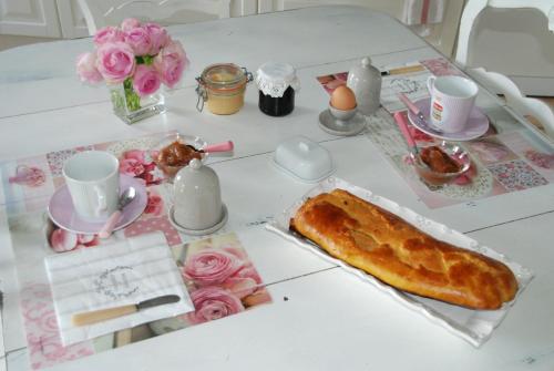 ein Tisch mit einem weißen Tisch mit einem Tischablage in der Unterkunft Chambre d'hotes "Les Paturelles" in Fougères-sur-Bièvre