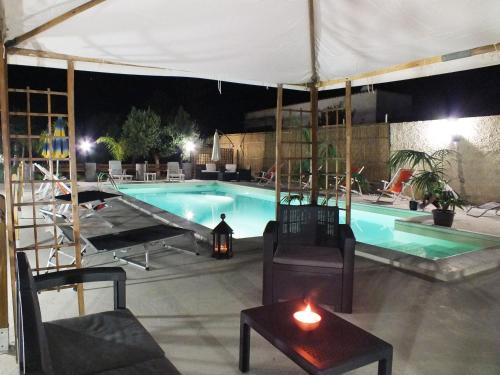 a swimming pool at night with a table and a candle at Zia Pia in Locogrande