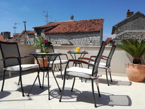 a patio with chairs and tables on a roof at Villa Ruzica in Trogir
