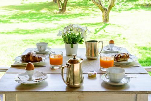 een houten tafel met ontbijtproducten en jus d'orange bij Hotel La Bussola in Marina di Massa