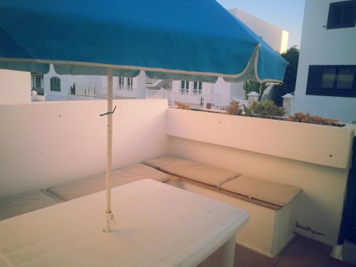 a table with an umbrella on top of a balcony at La casita de Esteban in Arrieta