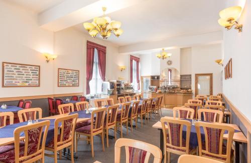 a restaurant with tables and chairs and a kitchen at City-Inn in Prague