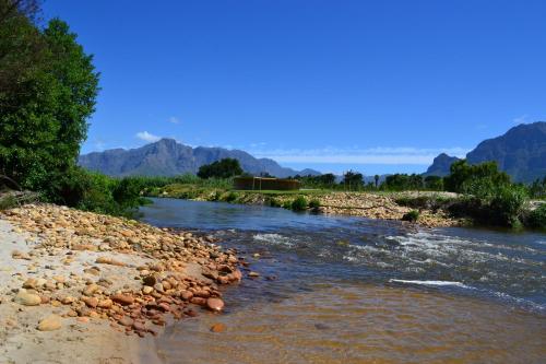 a river with rocks and mountains in the background at Pearl Valley-Golf Safari SA in Paarl