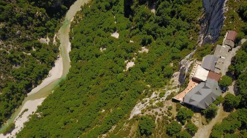 an aerial view of a house next to a river at Hotel Grand Canyon du Verdon in Aiguines