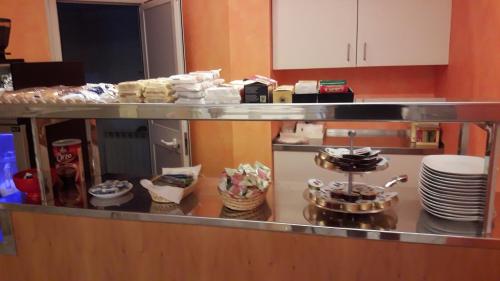 a kitchen with a counter with plates and pans at Albergo Nyers in Perugia