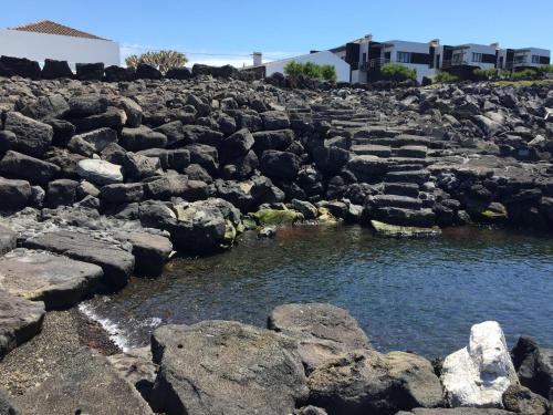 a rocky shore with a pool of water at Baia da Barca in Madalena