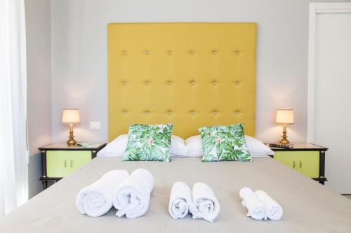 a bedroom with a bed with towels and two lamps at Naftalina Rooms in Termoli