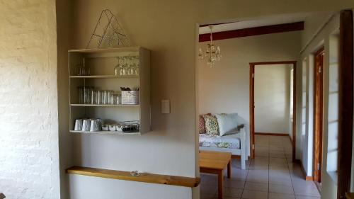 a room with a shelf with cups and a chair at Bella Manga Country Escape in Plettenberg Bay