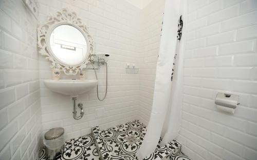 a white bathroom with a sink and a mirror at Öreg Malom Apartmanház in Bogács