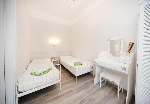 a white room with two beds and a desk at Öreg Malom Apartmanház in Bogács