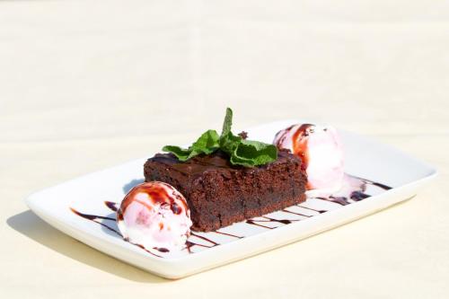 a piece of chocolate cake on a plate with ice cream at Pensiunea Gentiana in Bran