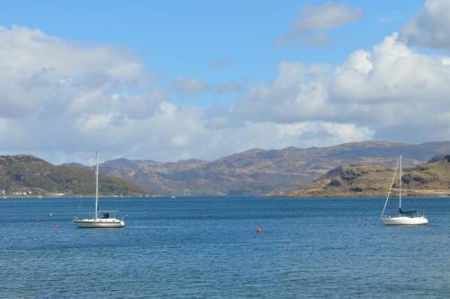 two boats floating in a large body of water at Taigh na Mara in Kames