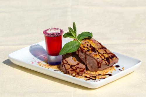 a chocolate dessert on a white plate with a drink at Pensiunea Gentiana in Bran