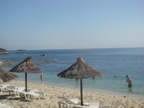 a beach with chairs and umbrellas and people in the water at Diamond Apartments & Suites in Hersonissos