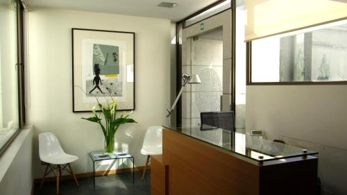 a bathroom with a glass counter and a vase of flowers at Heidelberg Haus Apart Hotel in Santiago
