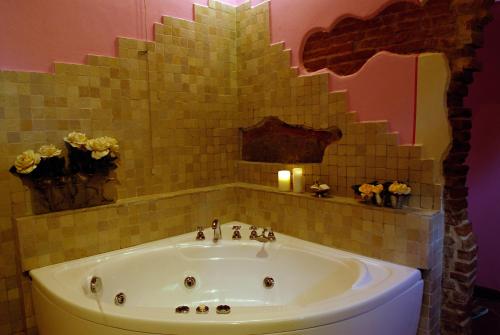a bathroom with a bath tub with a candle and flowers at Agrisalotto in Cortona