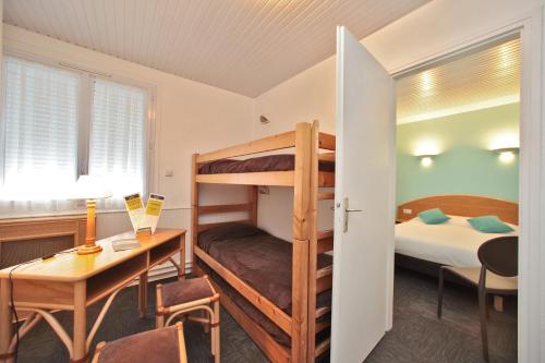 a room with a desk and a bunk bed at Hotel Les Dunes in La Tranche-sur-Mer