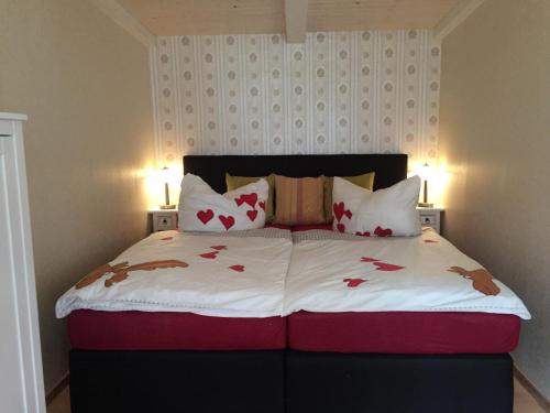 een slaapkamer met een bed met rode harten erop bij Bungalow am Schwielochsee in Schwielochsee