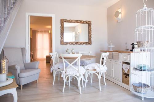 sala de estar con mesa, sillas y espejo en Le Saline Suites, en Carloforte