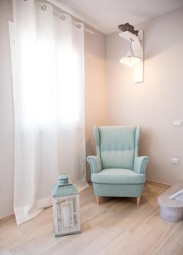 sala de estar con silla azul y lámpara en Le Saline Suites, en Carloforte