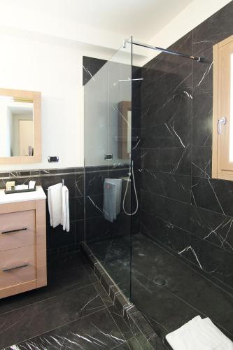 a bathroom with a shower with a glass door at Antica Civita Luxury Room in Matera