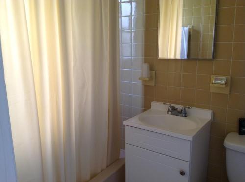 a bathroom with a sink and a shower curtain at Napoli Belmar Resort in Fort Lauderdale