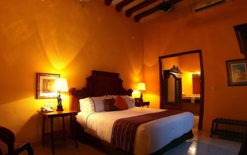 a bedroom with a large bed and a mirror at Hotel Boutique Casa Don Gustavo, Campeche in Campeche