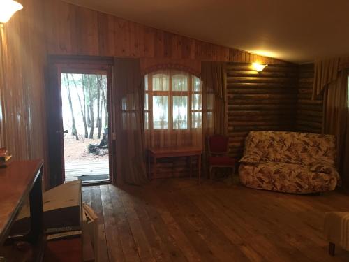 sala de estar con cama y ventana en Cottages on Gosdacha en Lidzava