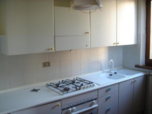 a white kitchen with a stove and a sink at B&B Passo del Cerreto in Cerreto Laghi